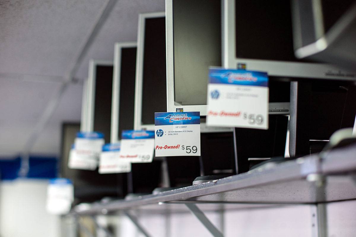 A row of computer monitors illustrating the retail sales portion of Alliance Computers